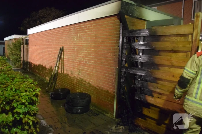 Auto met vloeistof besmeurd, schutting in brand gestoken