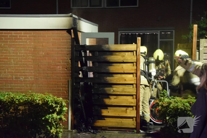 Auto met vloeistof besmeurd, schutting in brand gestoken