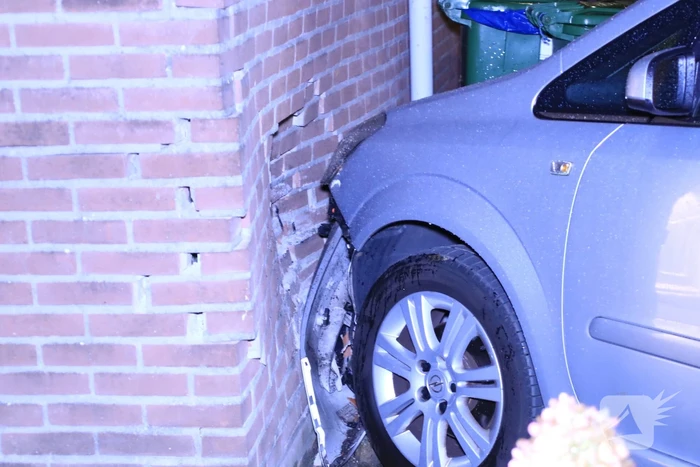 Geparkeerde auto ramt gevel na aanrijding