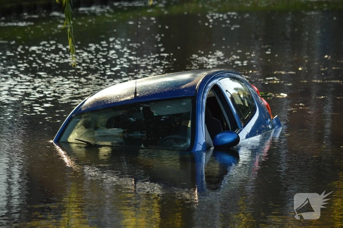 Automobilste rijdt met auto water in