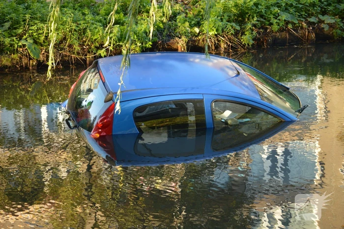 Automobilste rijdt met auto water in