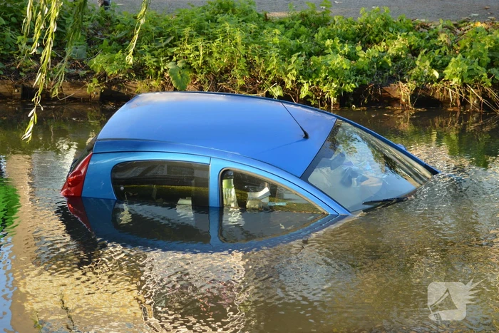 Automobilste rijdt met auto water in