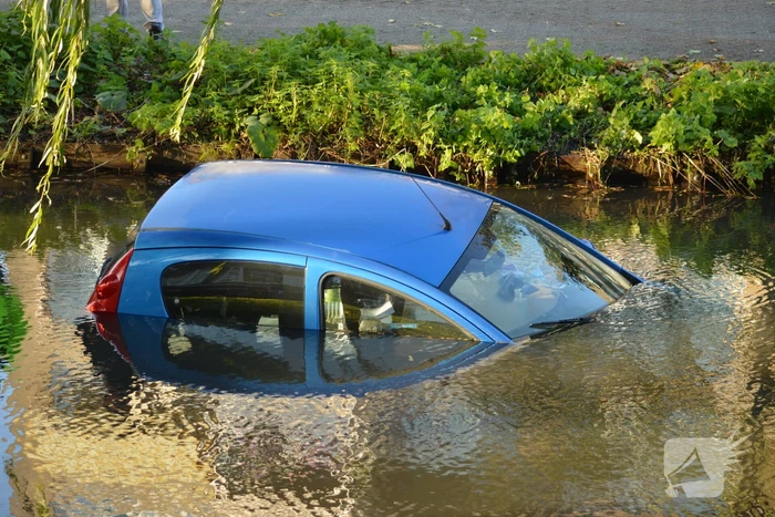 Automobilste rijdt met auto water in