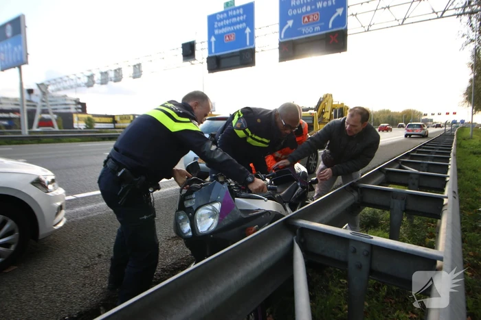 Motor belandt onder vangrail, bestuurder gewond