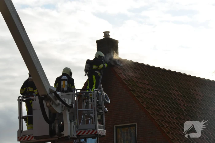 Brand in schoorsteen slaat door na dak