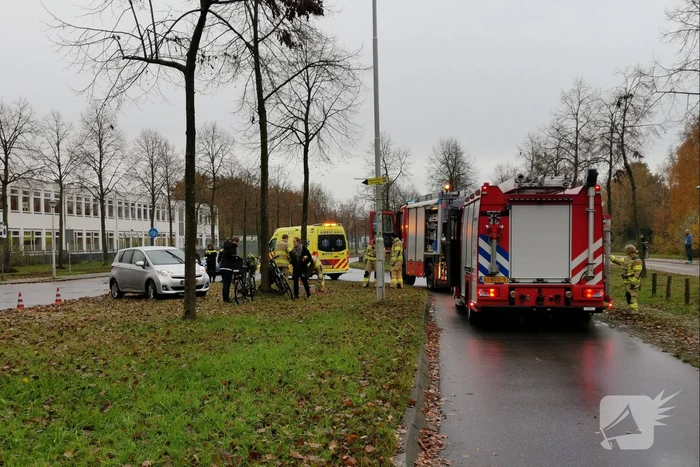 Fietser bekneld onder auto