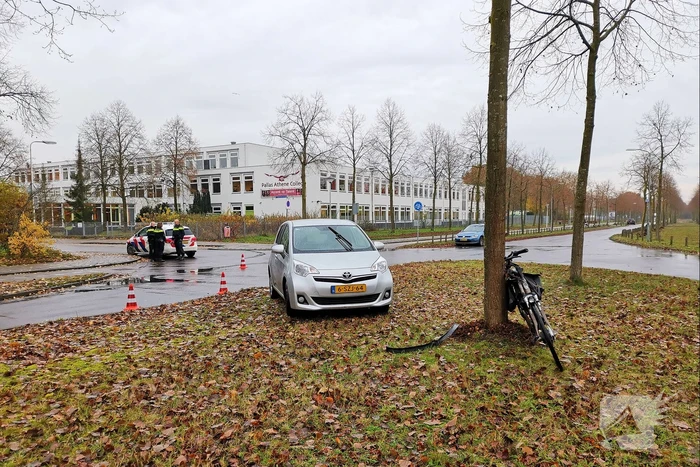 Fietser bekneld onder auto
