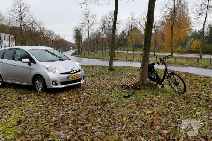 Fietser bekneld onder auto