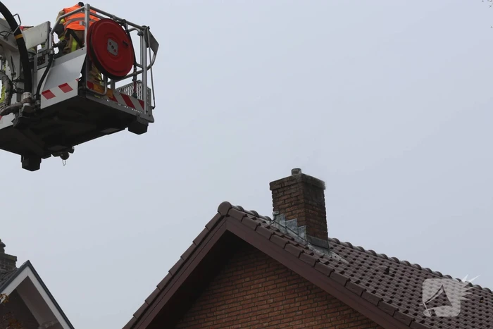 Brandweer veegt schoorsteen na brand
