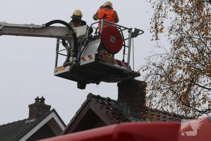 Brandweer veegt schoorsteen na brand
