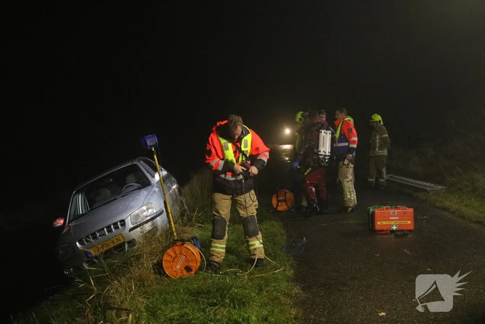 Auto raakt van dijk, brandweer doorzoekt sloot