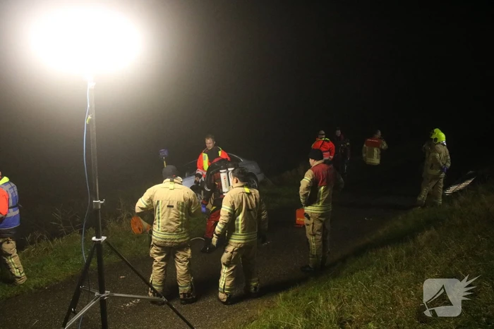 Auto raakt van dijk, brandweer doorzoekt sloot