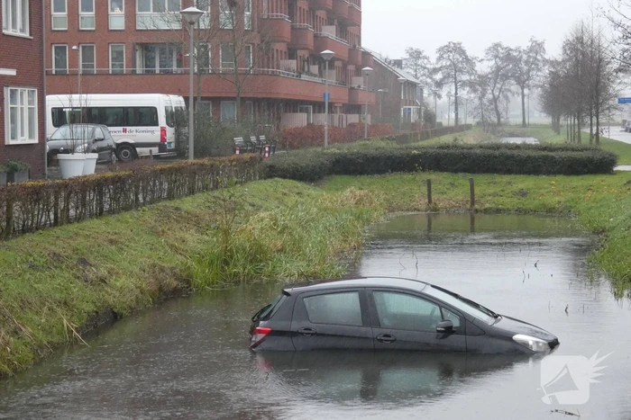 Auto achteruit de sloot in