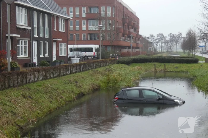 Auto achteruit de sloot in
