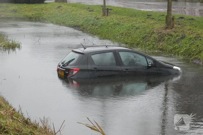 Auto achteruit de sloot in