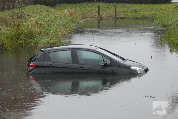 Auto achteruit de sloot in