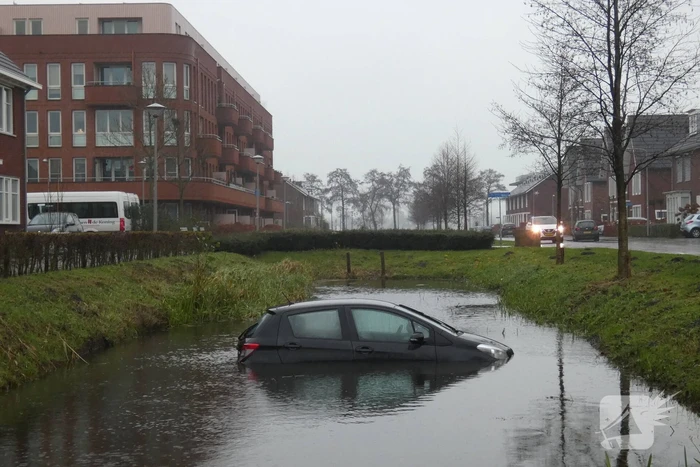Auto achteruit de sloot in