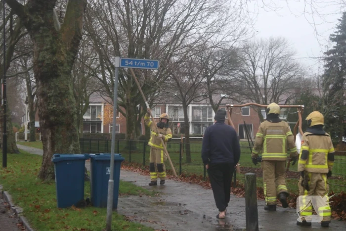 Brandweer haalt gevaarlijk loshangende takken uit boom
