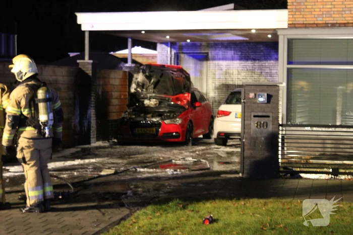 Auto in de brand onder carport