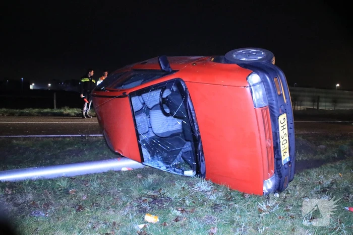 Auto op zijn kant, bestuurder gewond