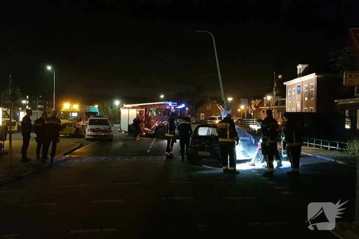 Auto op zijn kant na botsing met lantaarnpaal