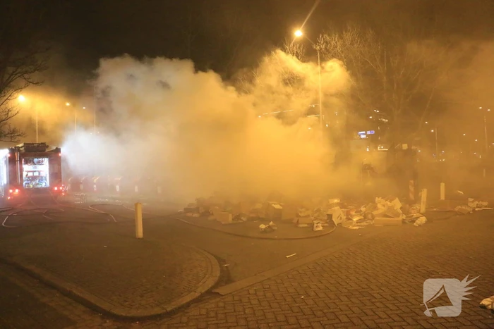 Brandweer druk met brand in container vol karton