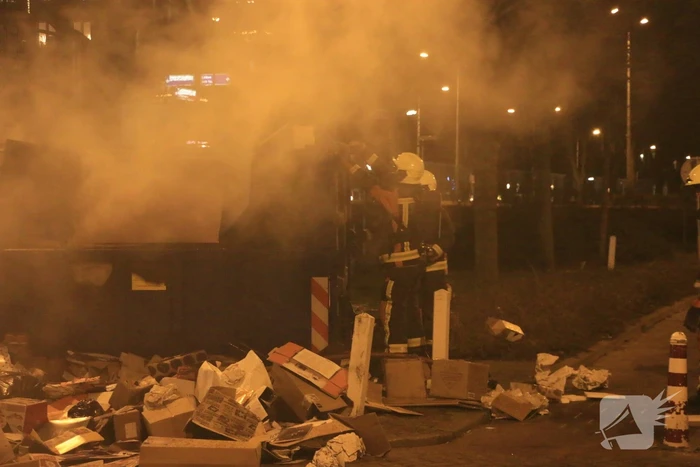 Brandweer druk met brand in container vol karton