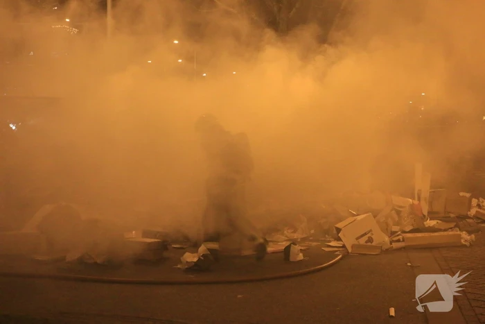 Brandweer druk met brand in container vol karton