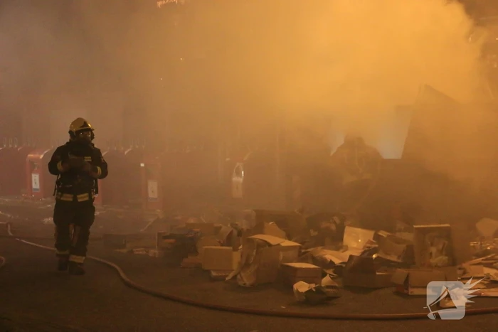 Brandweer druk met brand in container vol karton