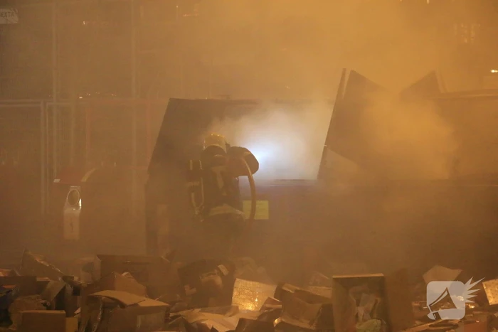 Brandweer druk met brand in container vol karton