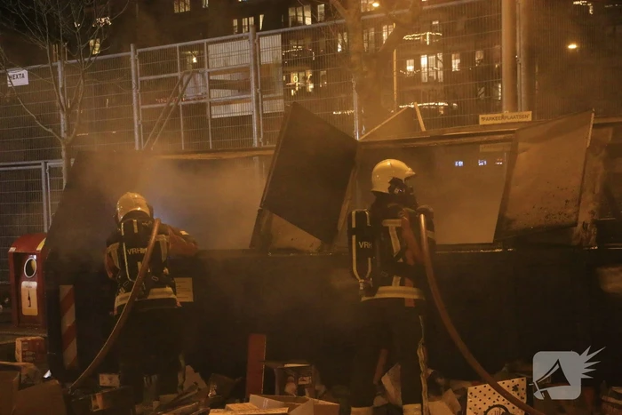 Brandweer druk met brand in container vol karton