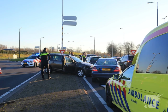 Twee personenauto's botsen op elkaar op rotonde