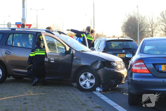 Twee personenauto's botsen op elkaar op rotonde