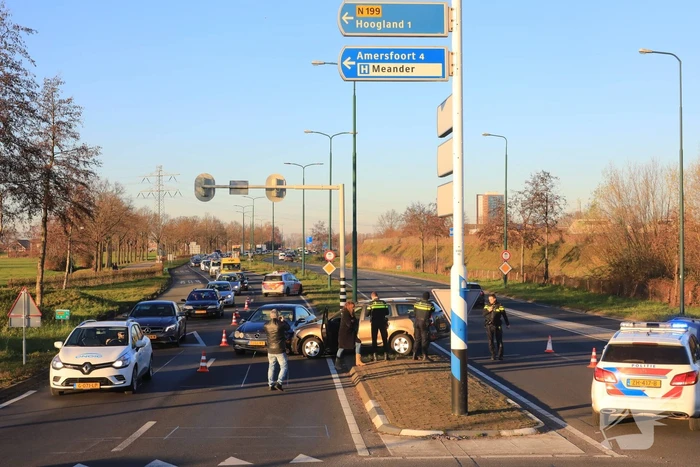 Twee personenauto's botsen op elkaar op rotonde