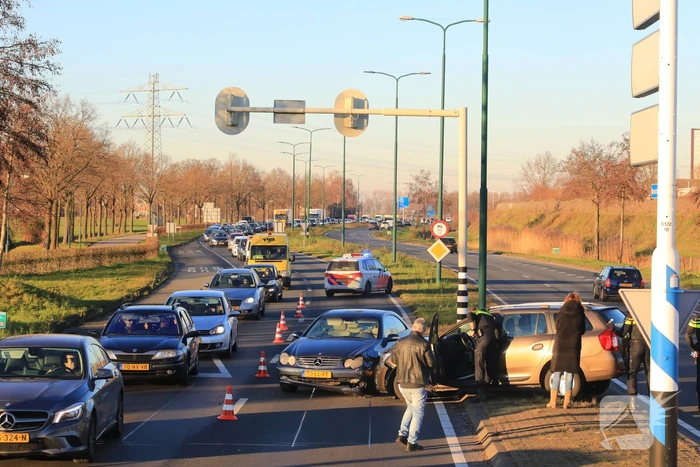 Twee personenauto's botsen op elkaar op rotonde