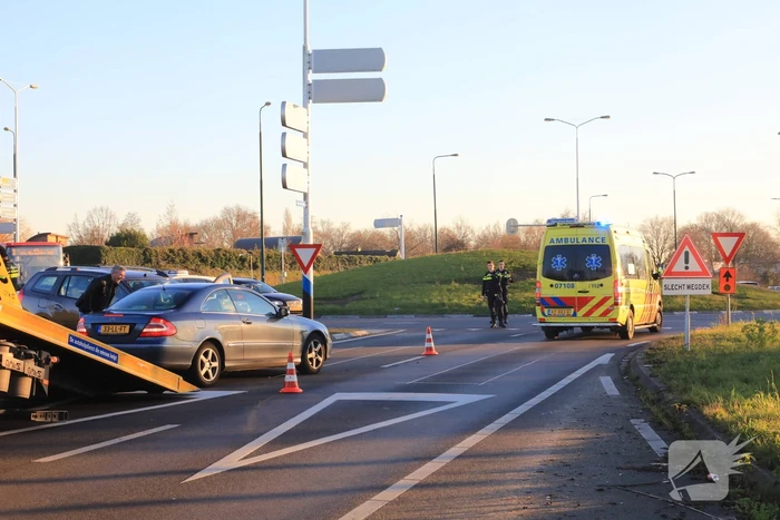 Twee personenauto's botsen op elkaar op rotonde