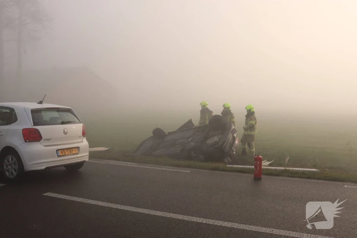 Auto op kop in sloot na botsing met andere auto