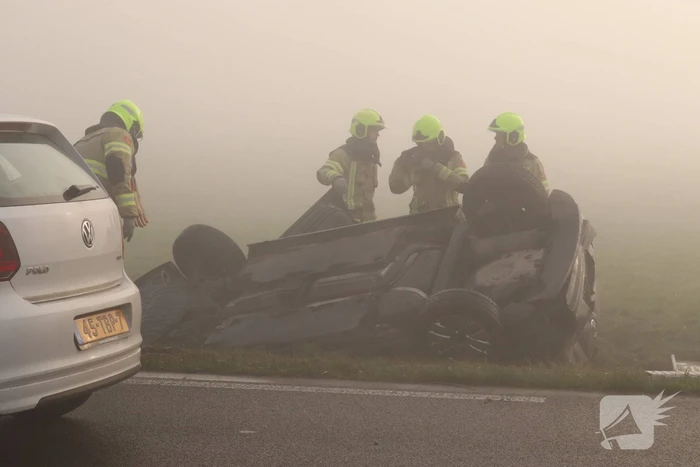 Auto op kop in sloot na botsing met andere auto