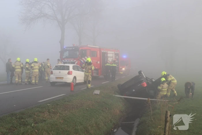 Auto op kop in sloot na botsing met andere auto