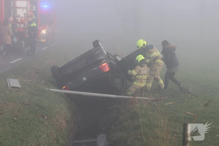 Auto op kop in sloot na botsing met andere auto