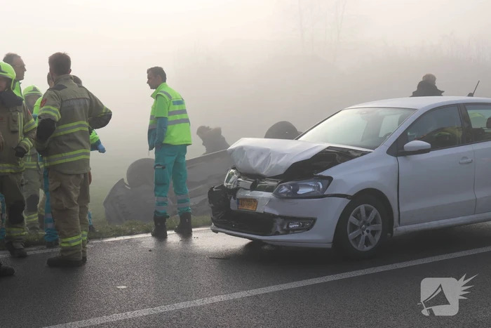 Auto op kop in sloot na botsing met andere auto