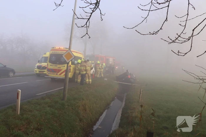 Auto op kop in sloot na botsing met andere auto