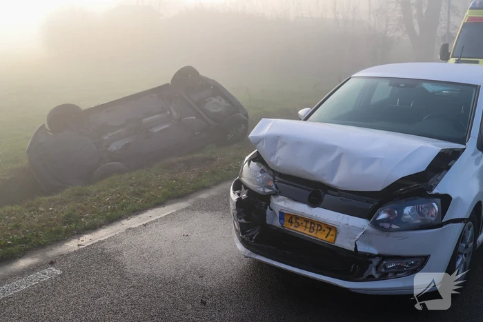 Auto op kop in sloot na botsing met andere auto