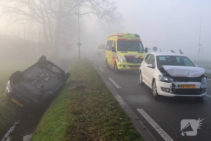 Auto op kop in sloot na botsing met andere auto