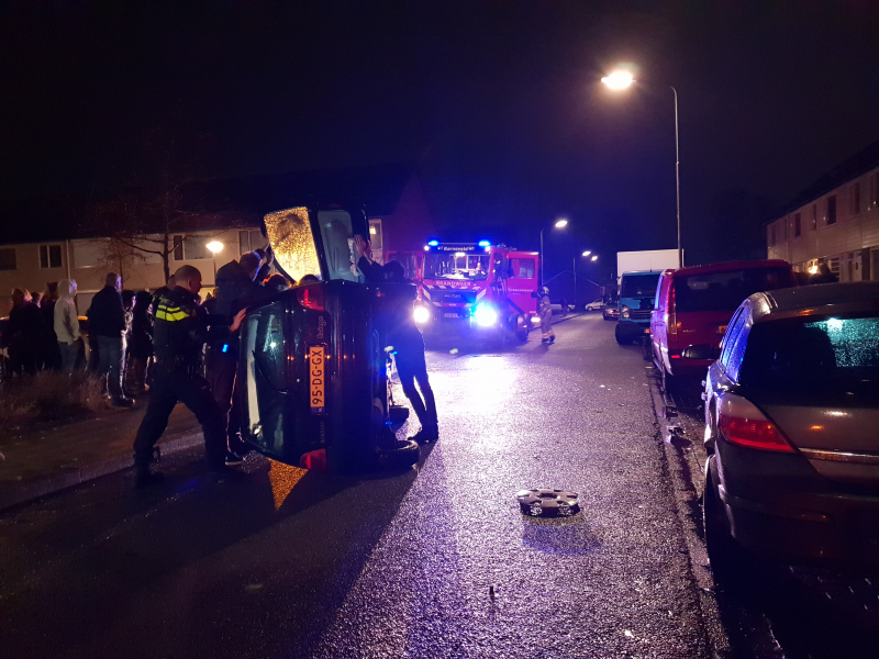 Bestuurster bekneld na auto op zijn kant