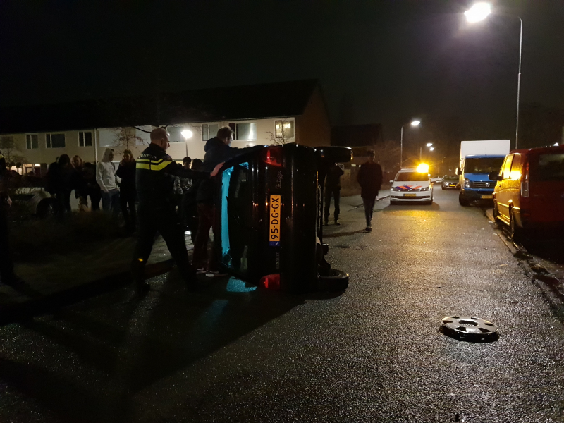 Bestuurster bekneld na auto op zijn kant