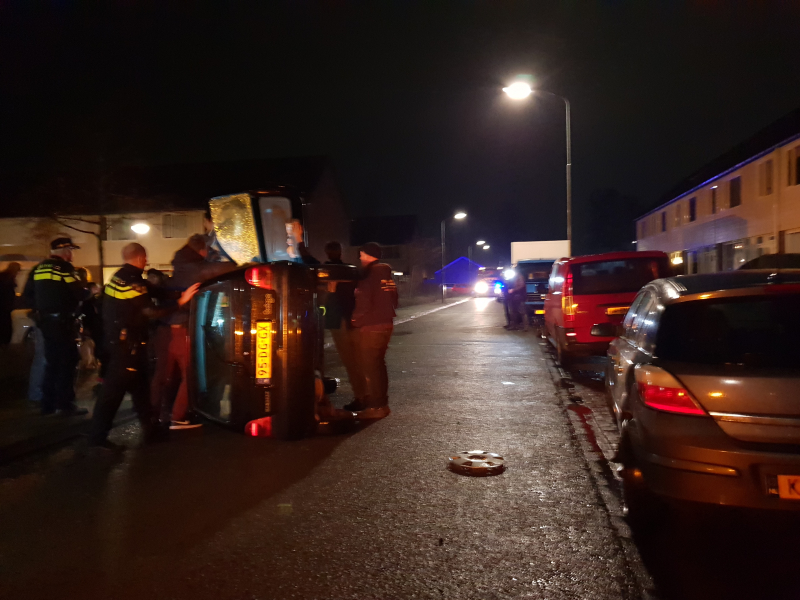 Bestuurster bekneld na auto op zijn kant