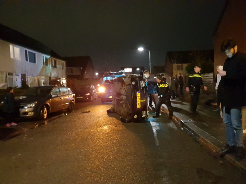 Bestuurster bekneld na auto op zijn kant