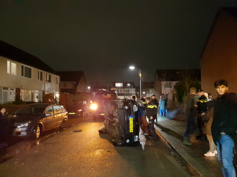 Bestuurster bekneld na auto op zijn kant