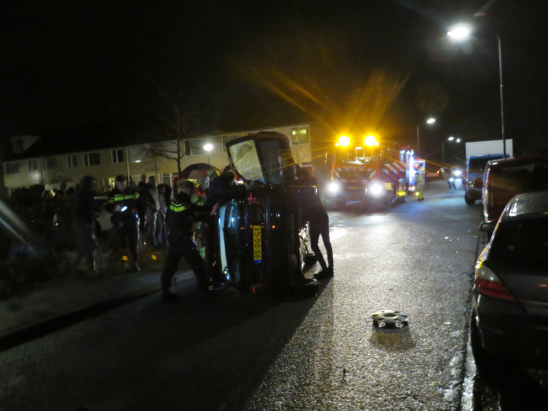 Bestuurster bekneld na auto op zijn kant